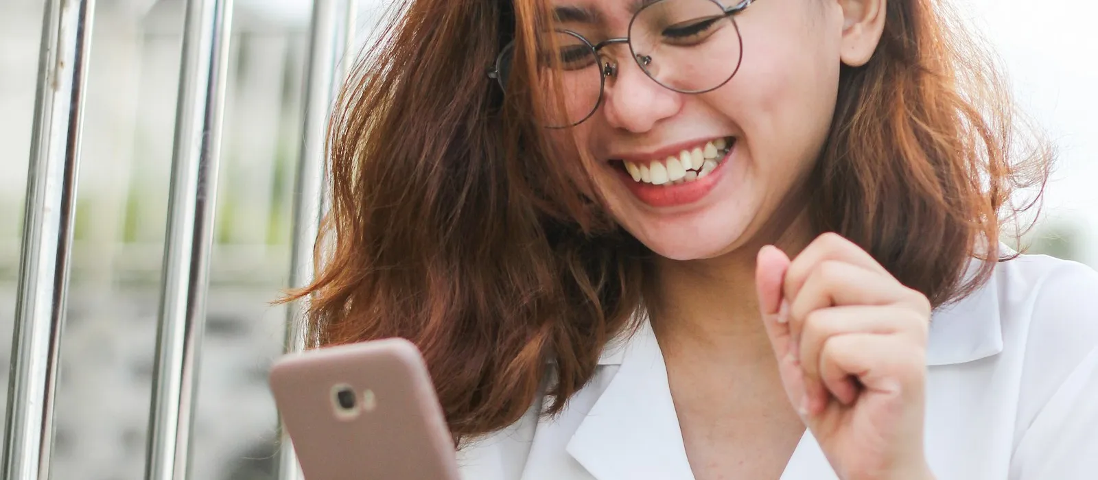 Femme souriante et détendue en train de regarder son téléphone, illustration du fait que faire des erreurs aide à progresser