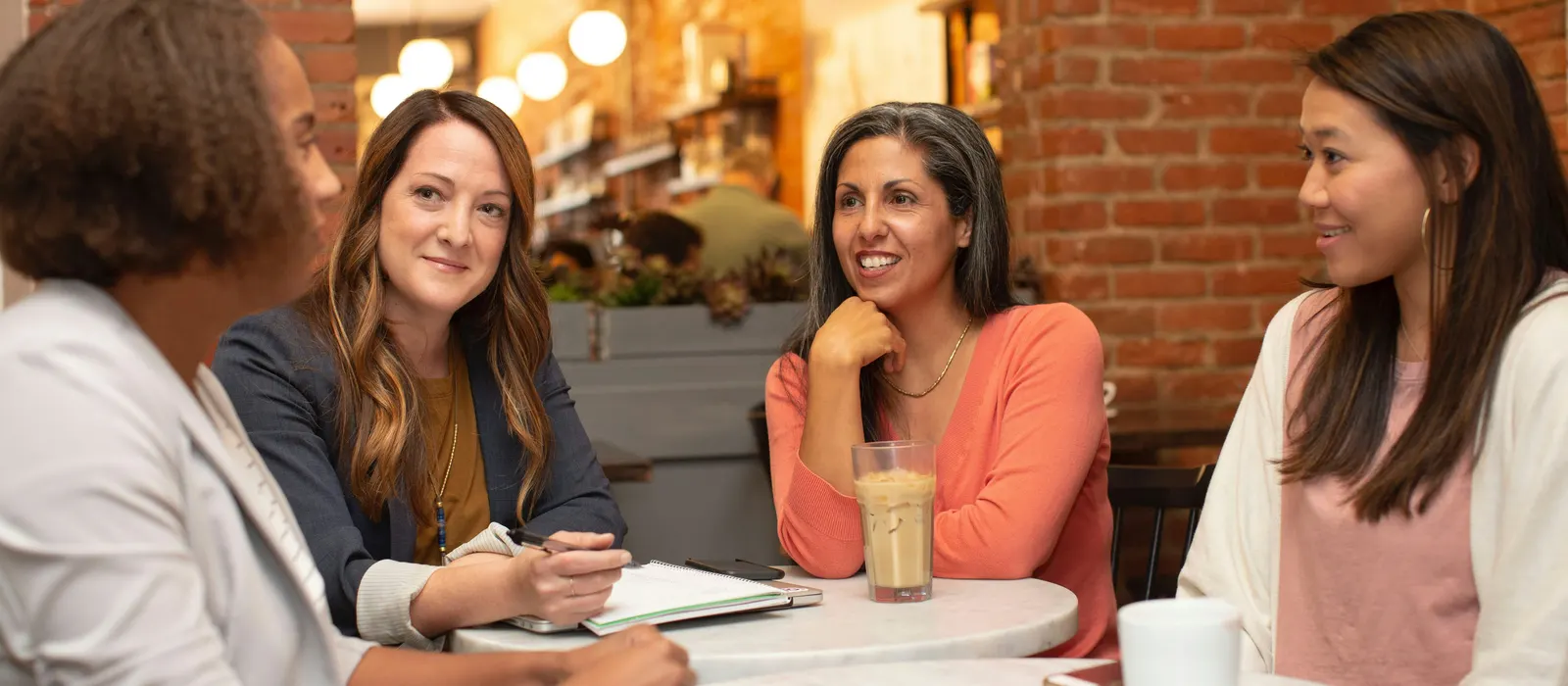 Groupe de femmes qui discutent autour d'une table, illustration de comment se faire connaître sans LinkedIn