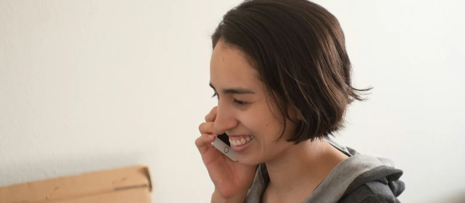 Femme souriante au téléphone, illustration de la recherche des premières clientes