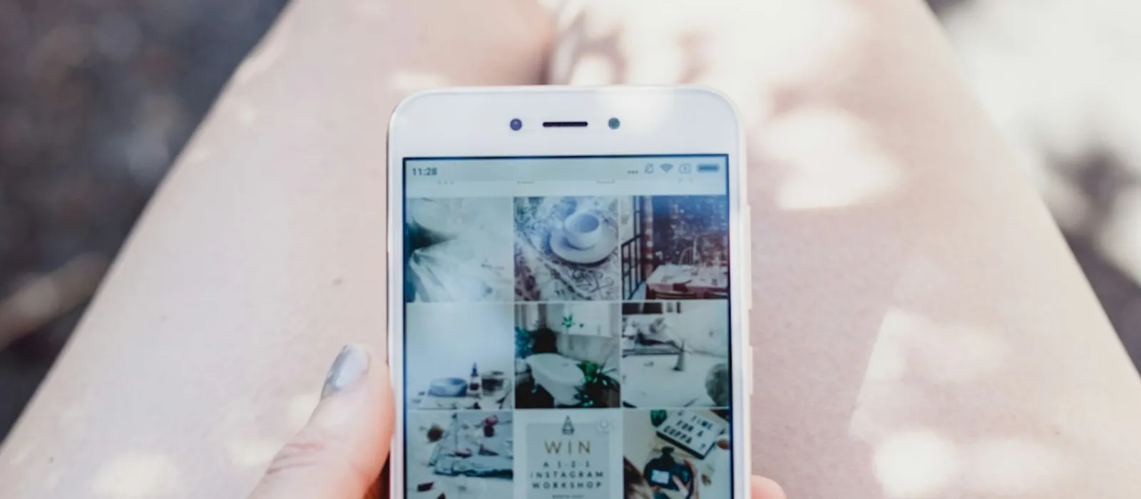 Une main tient un téléphone qui affiche un fil Instagram