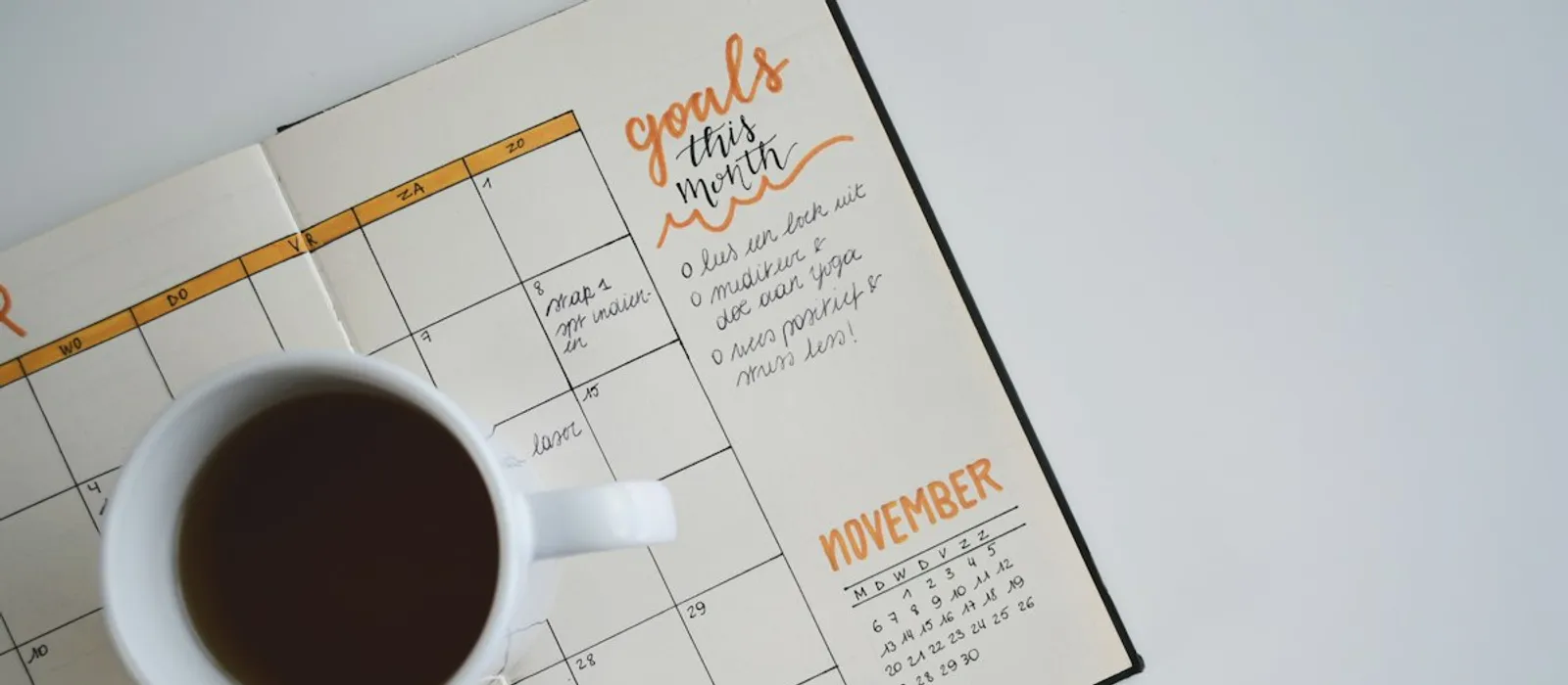 Un mug de café posé sur un agenda ouvert