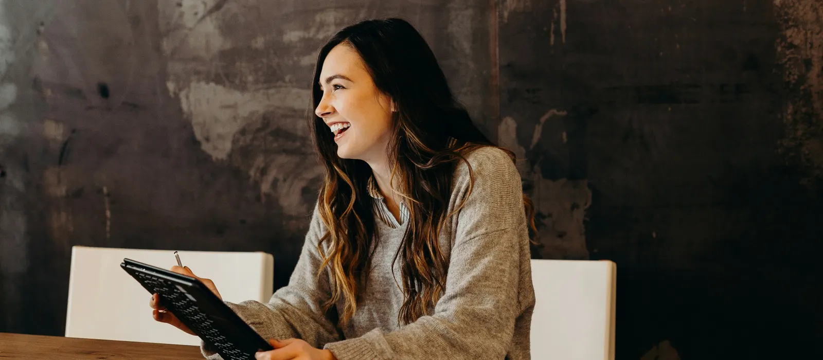 Femme confiante qui sourit en tenant une tablette, illustration de se lancer sans réseau ni argent